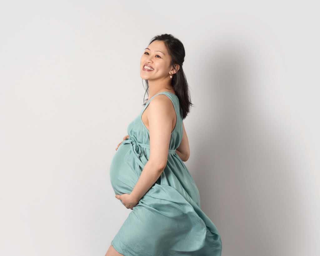 Pregnancy portrait in green silk dress