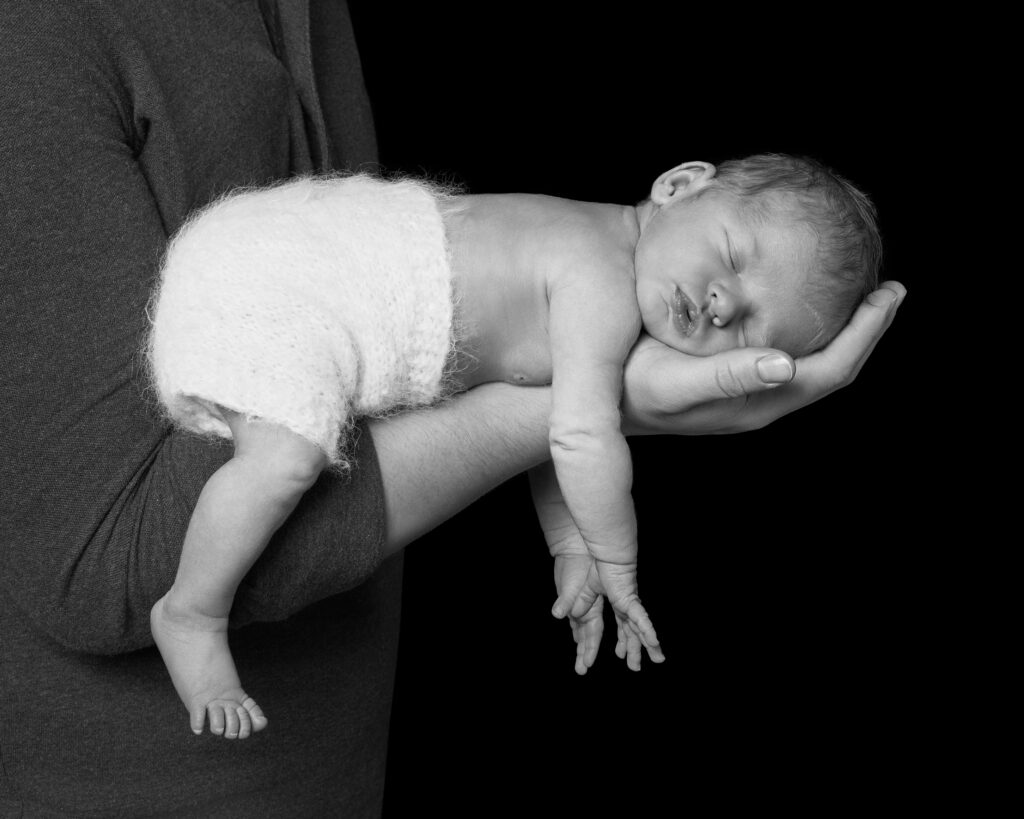 Sleeping baby on father's arm in black and white