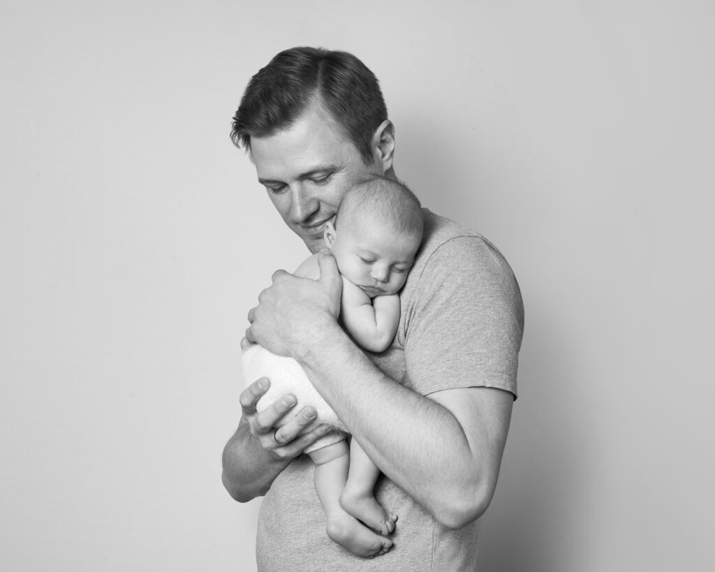 Father cradling baby during photoshoot in Brockley