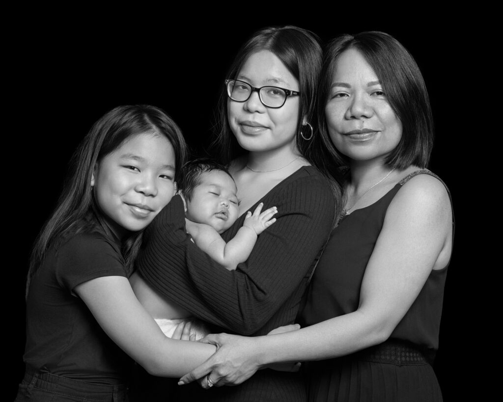 Motherhood portrait. Mother and her three daughters in a tender black & white portrait. The photograph is by Elle Fallon Photography and taken in London